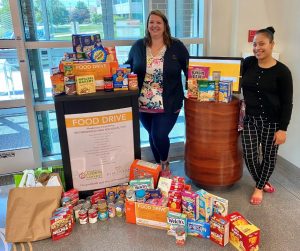 Discovery FCU employees with a collection of food for the food drive