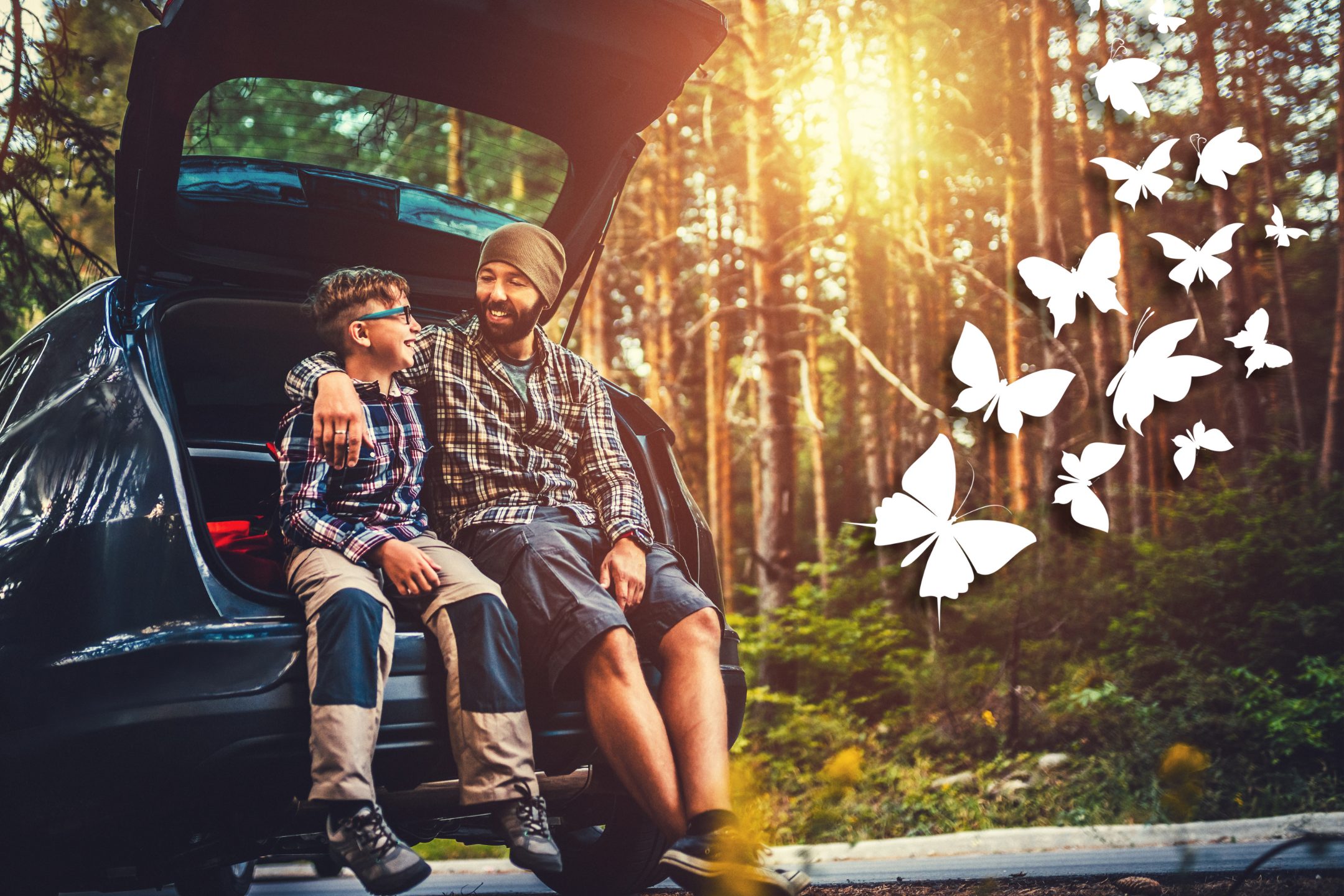 father and son sitting in the open back of a refinanced car preparing for a hike