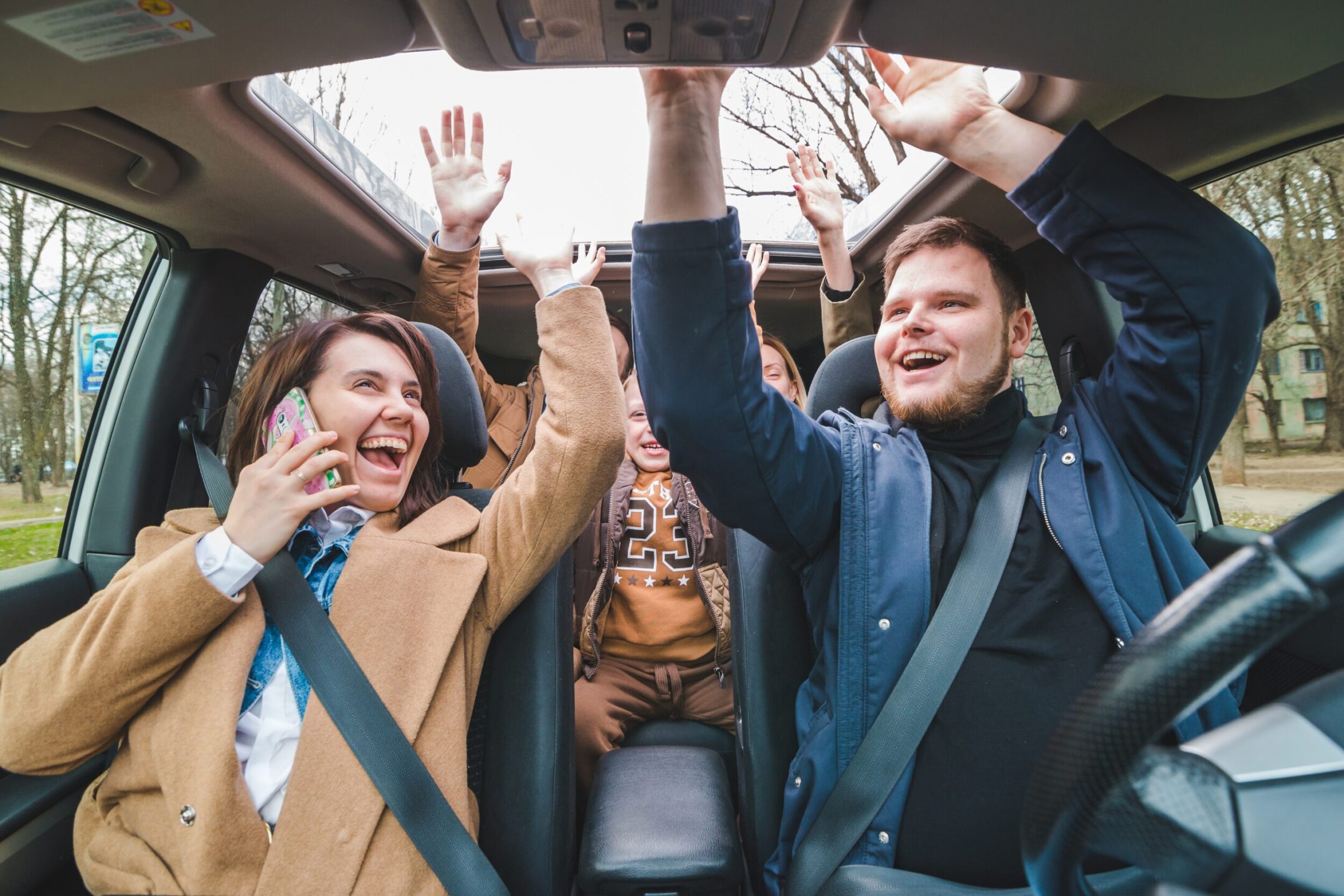 Family in car with hands up