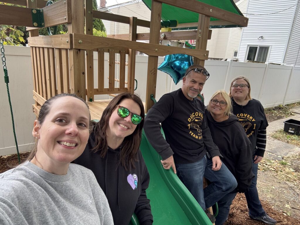 Discovery FCU team poses in front of built playset.
