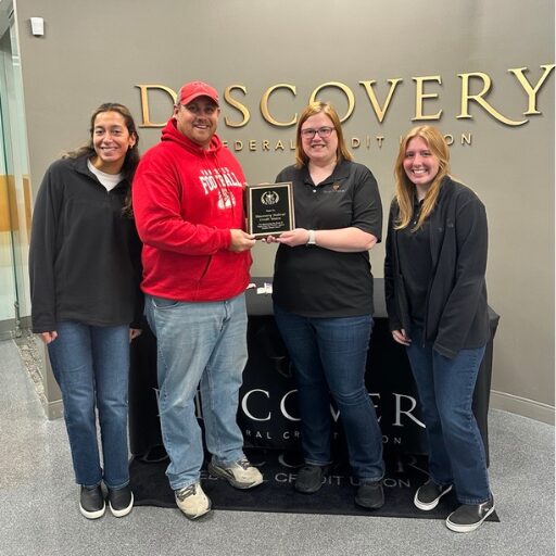 Standing together holding an award