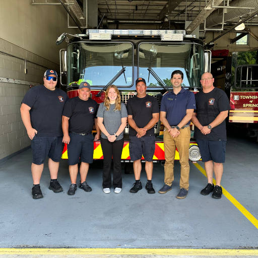 images for community involvement page 2 | Discovery FCU Six firefighters stand in a station bay in front of a red fire engine, posing for a group photo in dark uniforms.